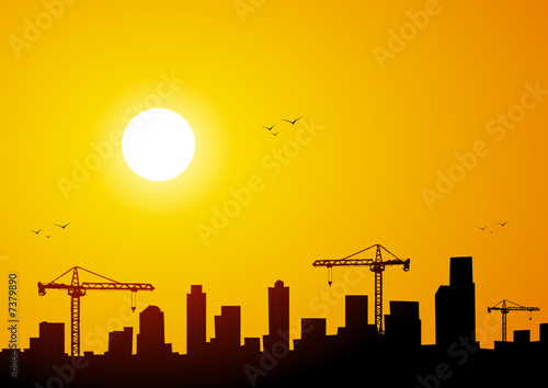 City at sunset with cranes