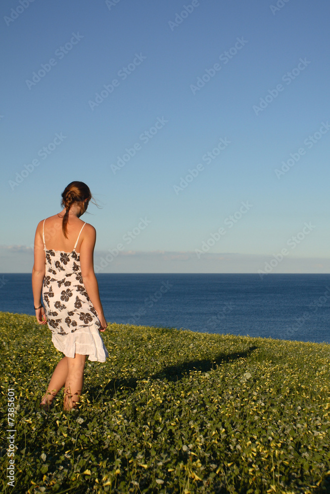 Pretty girl in dress looking at the ocean