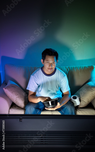 Man watching television alone at night
