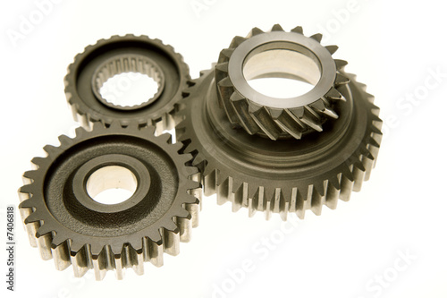 Three gears meshing together over white