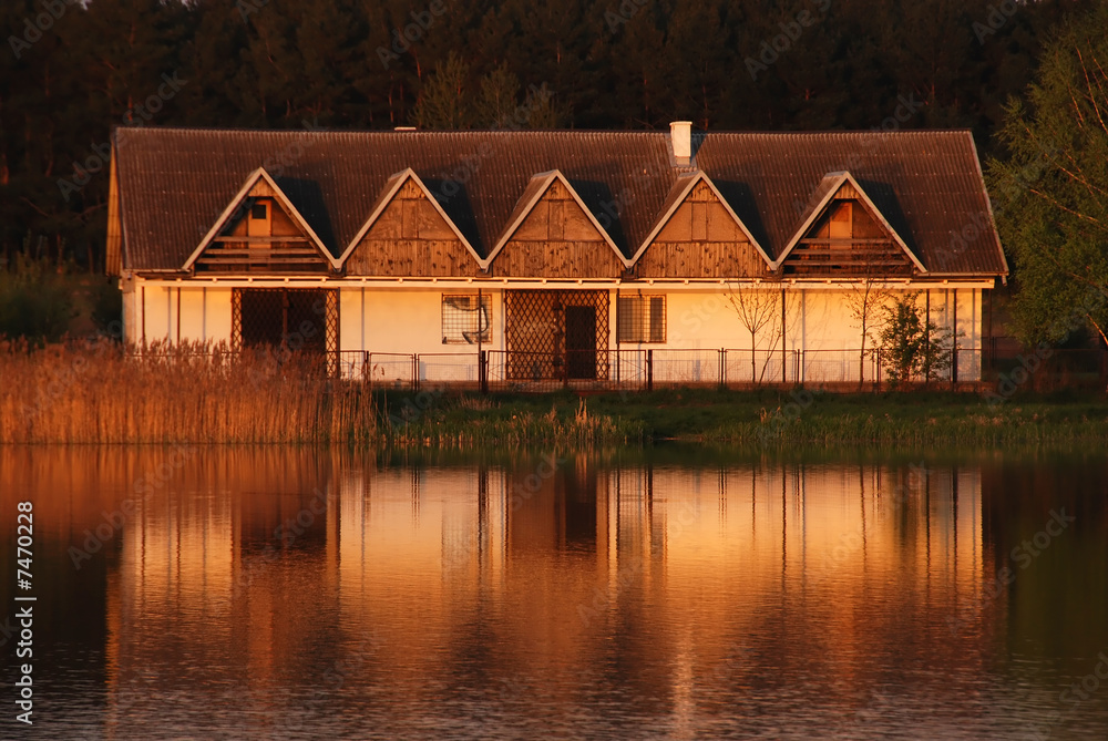Old abandoned building reflecting in the lake at sunset Old abandoned building reflecting in the lake at sunset