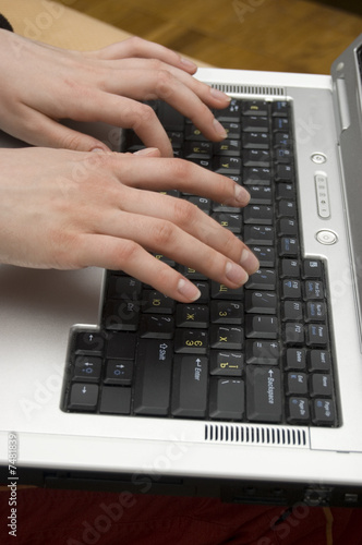 Female hands typing on a laptop with a Russian keyboard