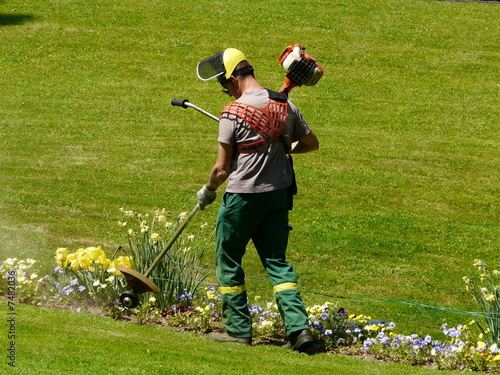 jardinier maniant une tondeuse à essence photo