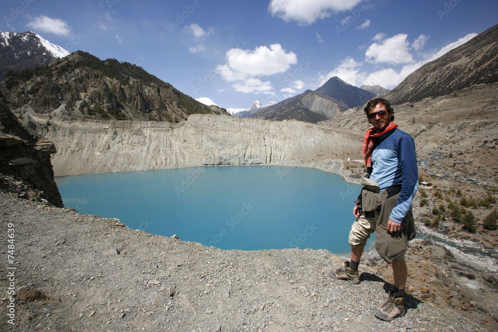Fototapeta premium man standing on the edge of cliff overlooking blue mountain