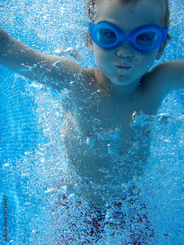 Junge taucht im Schwimmbad photo