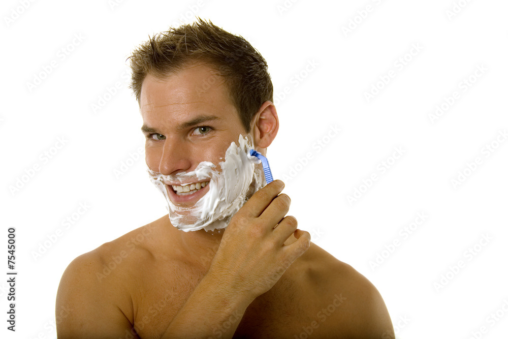 Young man shaving his beard
