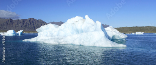 Panoramic view of an iceberg against a blue sky