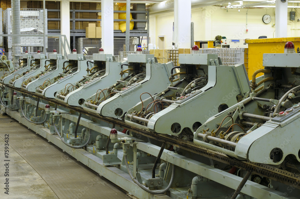 Row of stitching machines for binding booklets in publishing