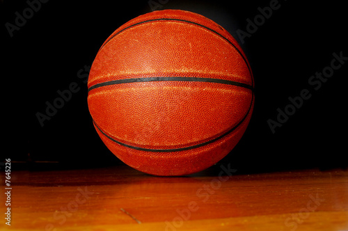 Basketball on the gym floor, on black