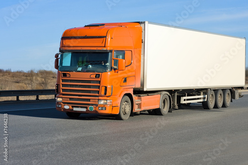 orange truck with white container on road