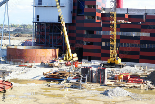 cranes and chinmey on construction of industrial factory photo