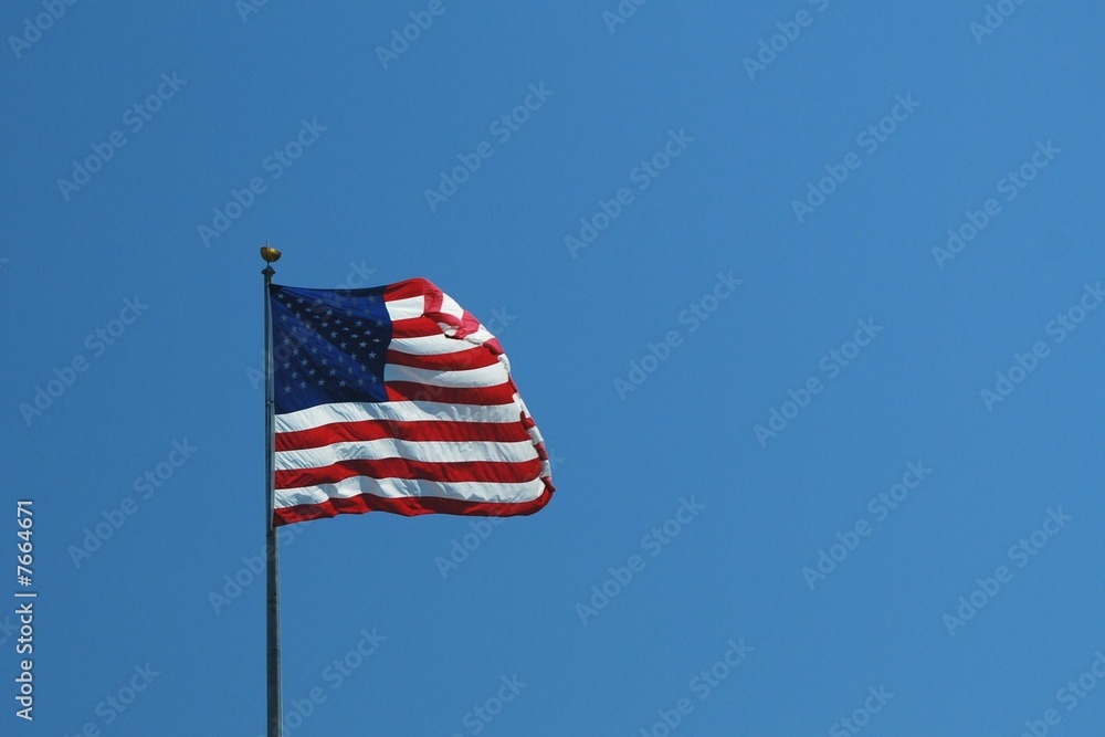 US flag fying against blue sky