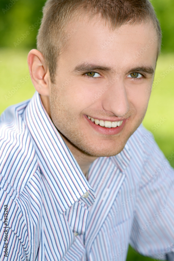Fototapeta premium Smiling man on the green outdoors.