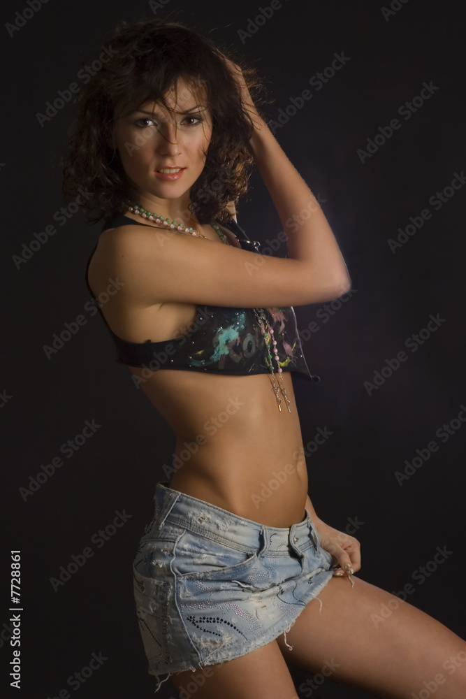Fototapeta premium Smiling girl in mini skirt posing in studio