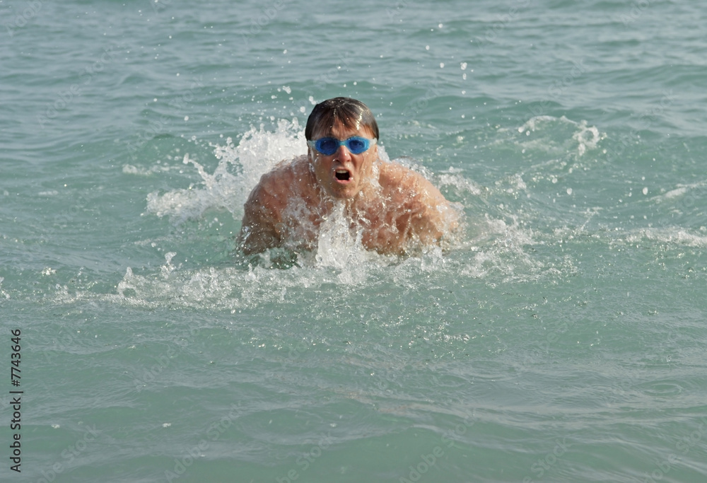 A man swimming breastroke in the sea.