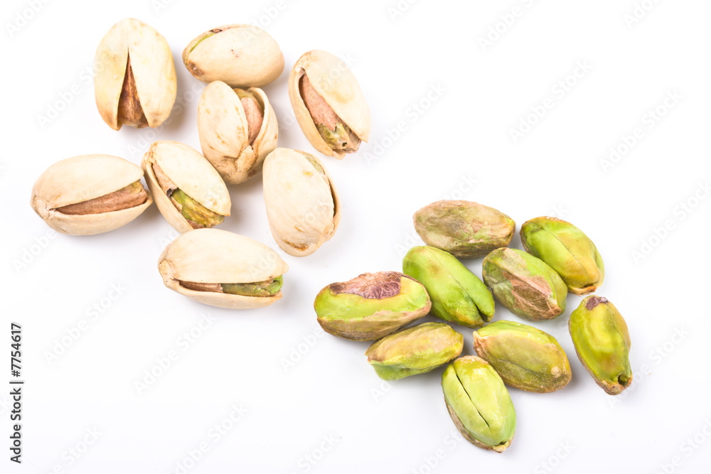 Several pistachio nuts naked and in shell close up isolated