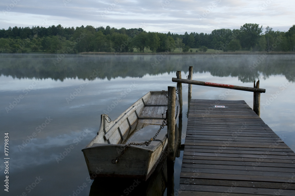 Naklejka premium Misty dawn. Boat at the pier