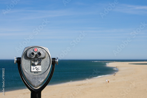 Coin operated binoculars for beach observation, blue sky and oce