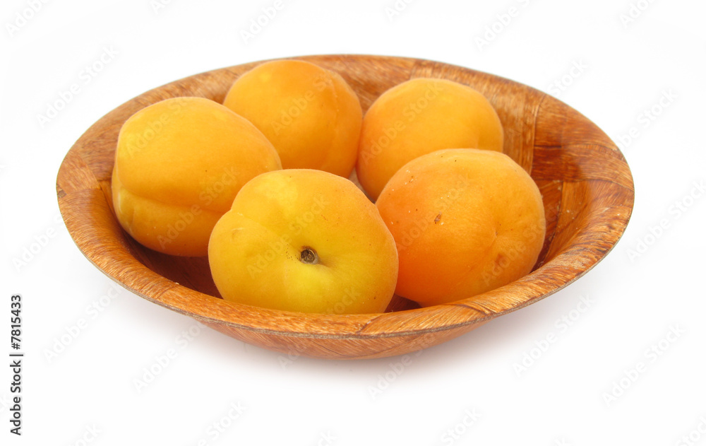 Apricots in wooden dish isolated on white background Apricots in wooden dish isolated on white background