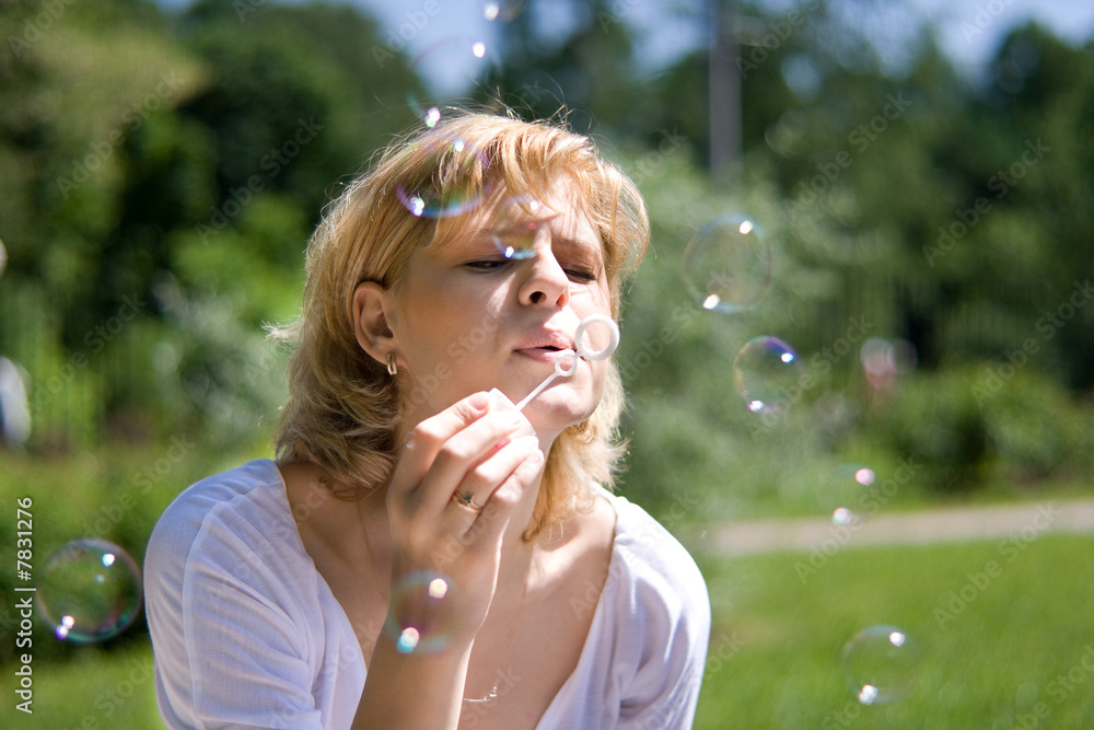 Young women makes soap bubbles