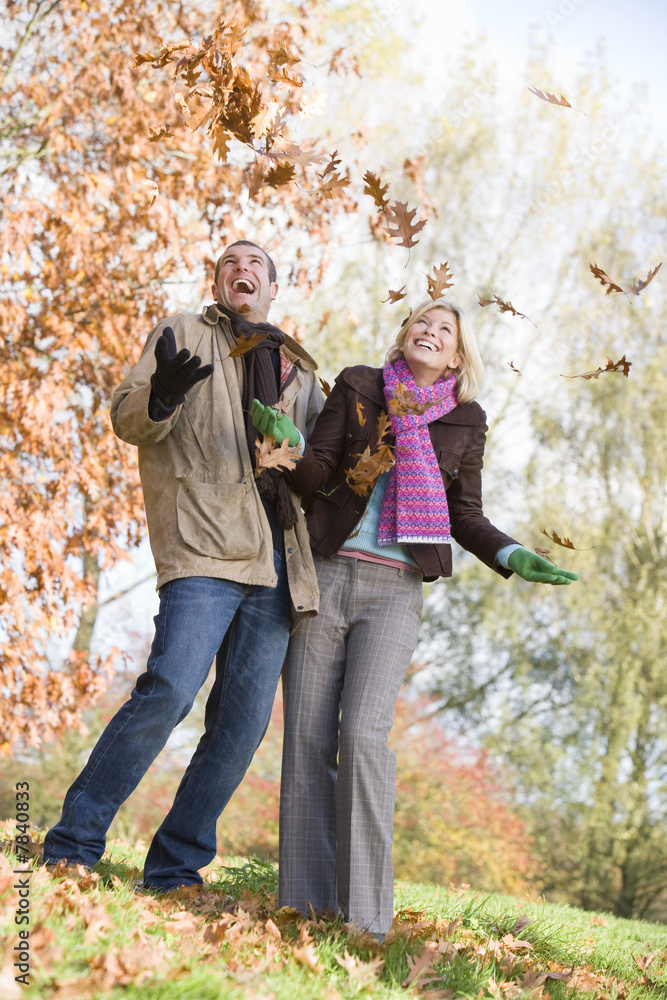 Young couple having fun with autumn leaves Young couple having fun with autumn leaves