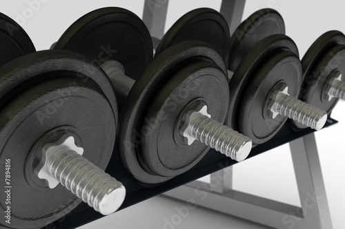 row of metal dumbbells on support