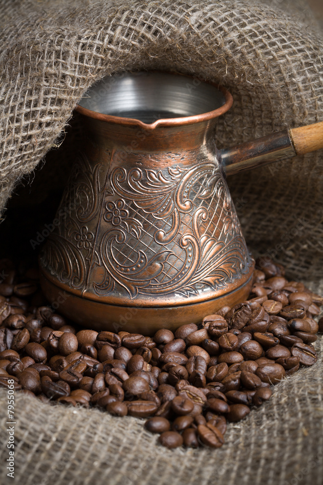 Cezve with freshly roasted coffee beans on sackcloth Cezve with freshly roasted coffee beans on sackcloth