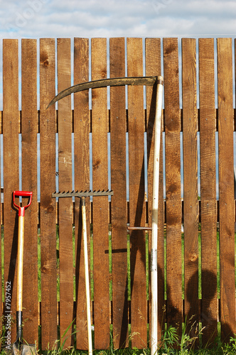 garden tool set over wood backyard fence