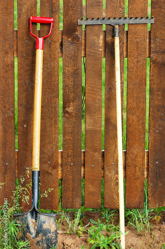 garden tool set over wood backyard fence
