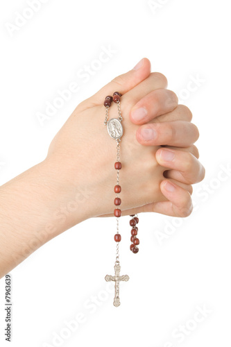 Hands closed in prayer with a rosary 