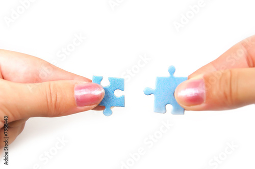 female hands putting together right puzzle isolated on white