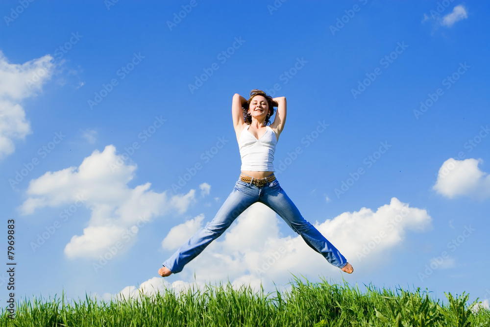 happy young woman jumping in green grass happy young woman jumping in green grass