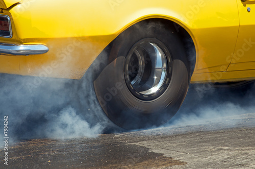 Smoke from the tires of a yellow racer