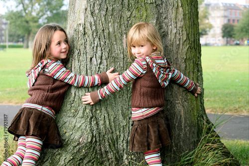 Sisters hugging a tree