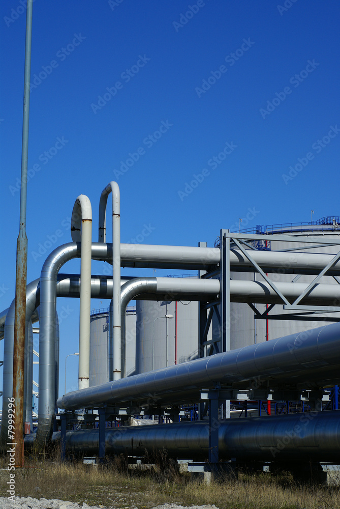 industrial pipelines and storage tanks against blue sky industrial pipelines and storage tanks against blue sky
