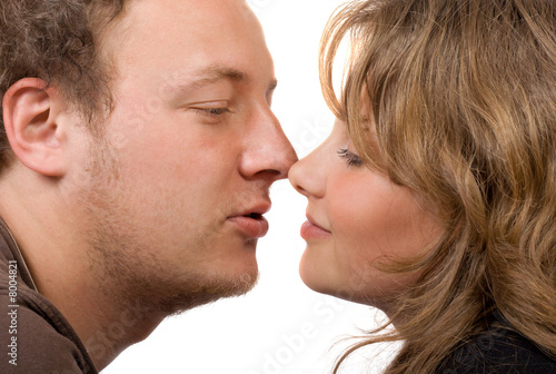 Portrait of young kissing couple. Isolated on white