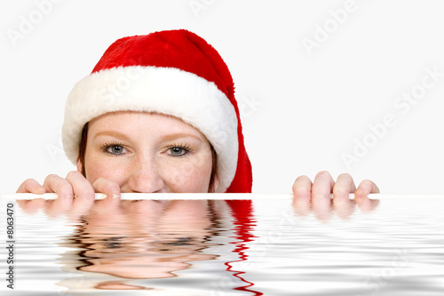 Christmas faerie looking over the edge of a pool