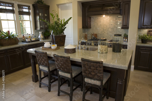 Modern designer kitchen with brown tiles and a granite island.