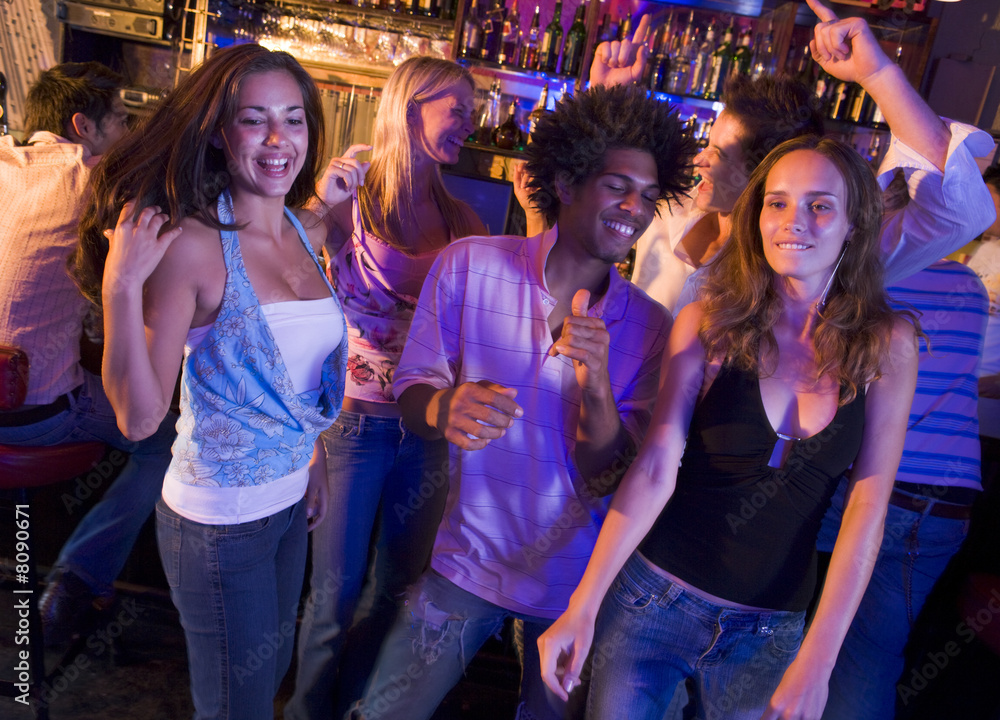 Young men and women dancing in a nightclub Young men and women dancing in a nightclub