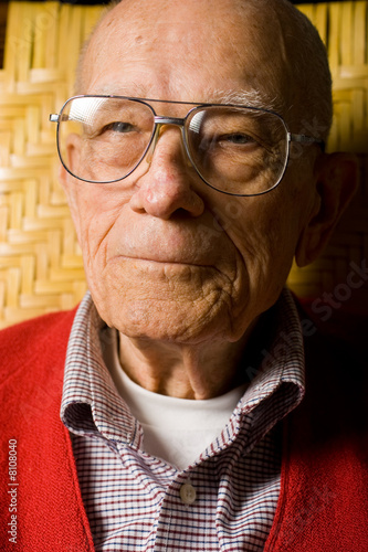 Senior Man Sitting pleasant look on face.  Close Up.