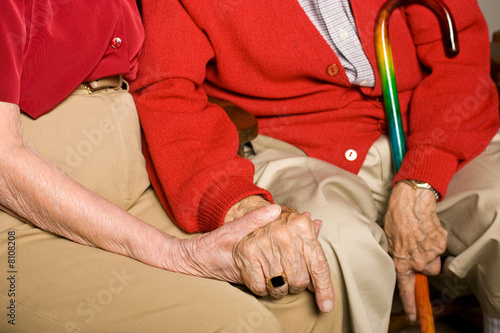 Senior Man and Woman Sitting  Holding Hands.   Being Together.