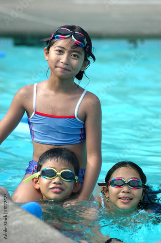 Three children in the pool © verinize