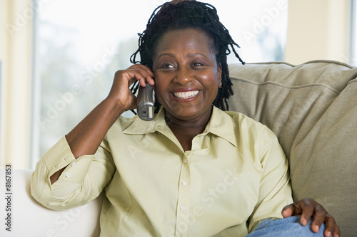 Photography Woman sitting in living room using telephone and smiling