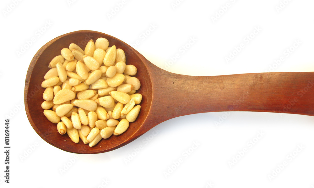 Pine nuts edible seeds in wooden spoon Pine nuts edible seeds in wooden spoon