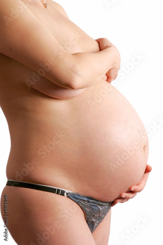 Pregnant woman belly with hands arround on white