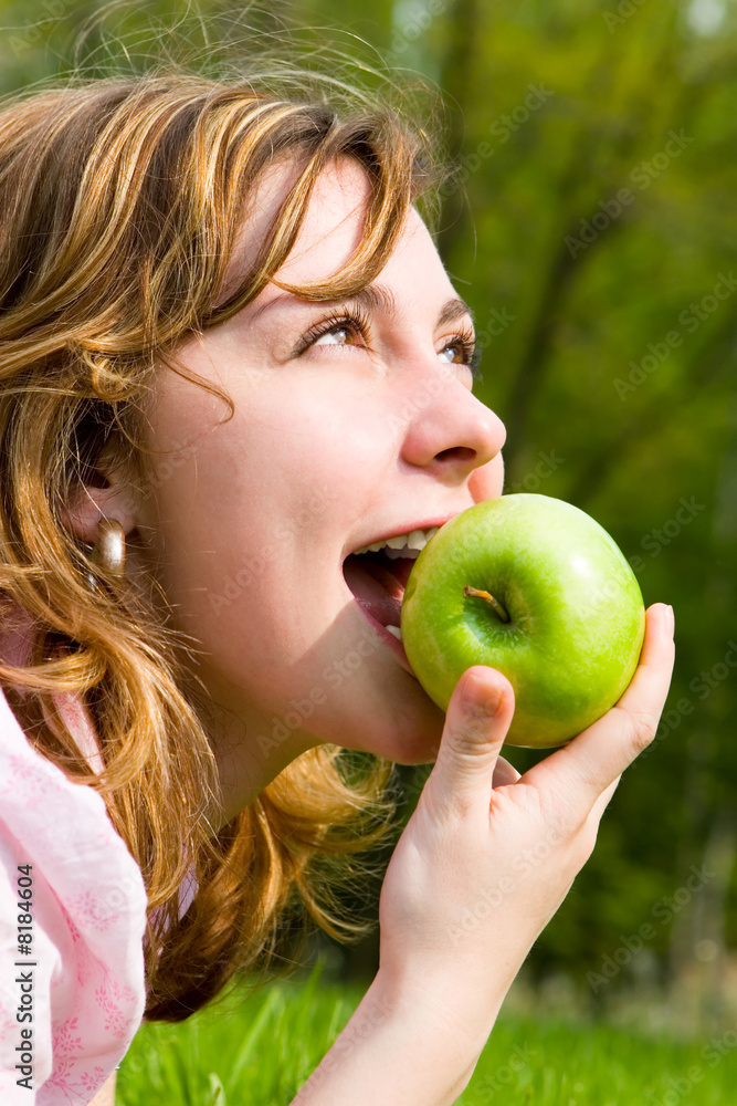 pretty woman eating green apple on the summer glade pretty woman eating green apple on the summer glade