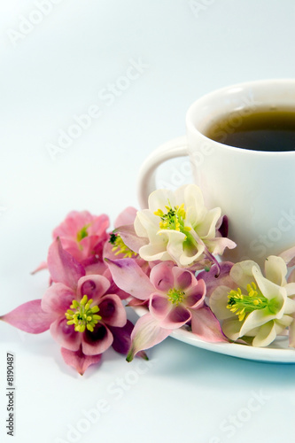 White teacup with tea and flowers