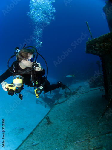 Underwater Photographer looking at a Sunken Ship