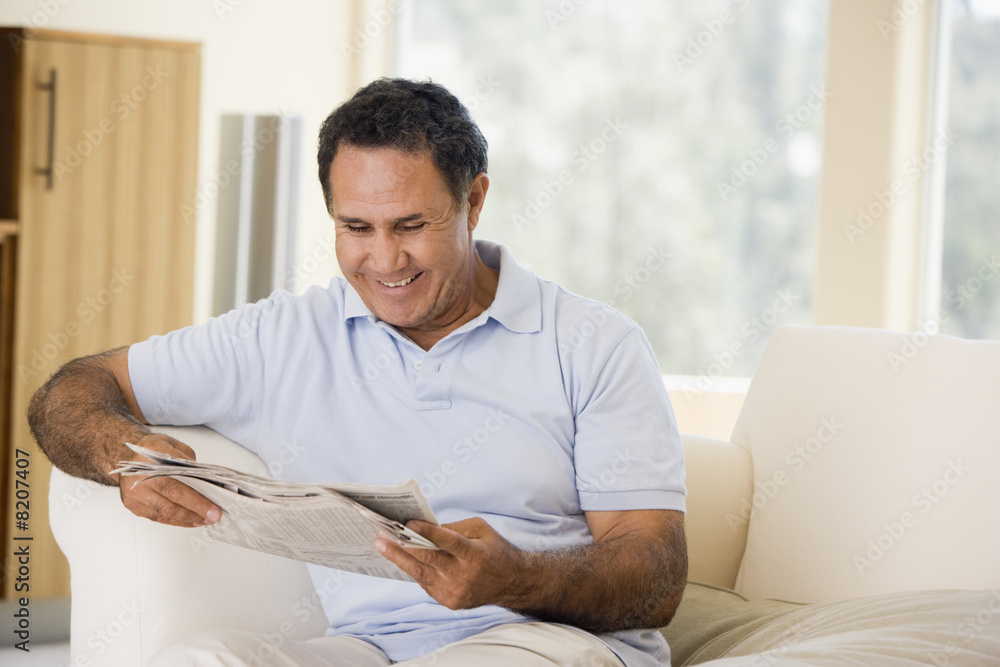 Man relaxing with newspaper in living room