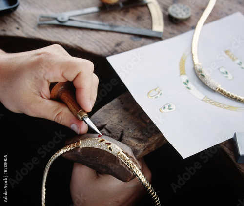 mains de l'orfèvre sur un collier